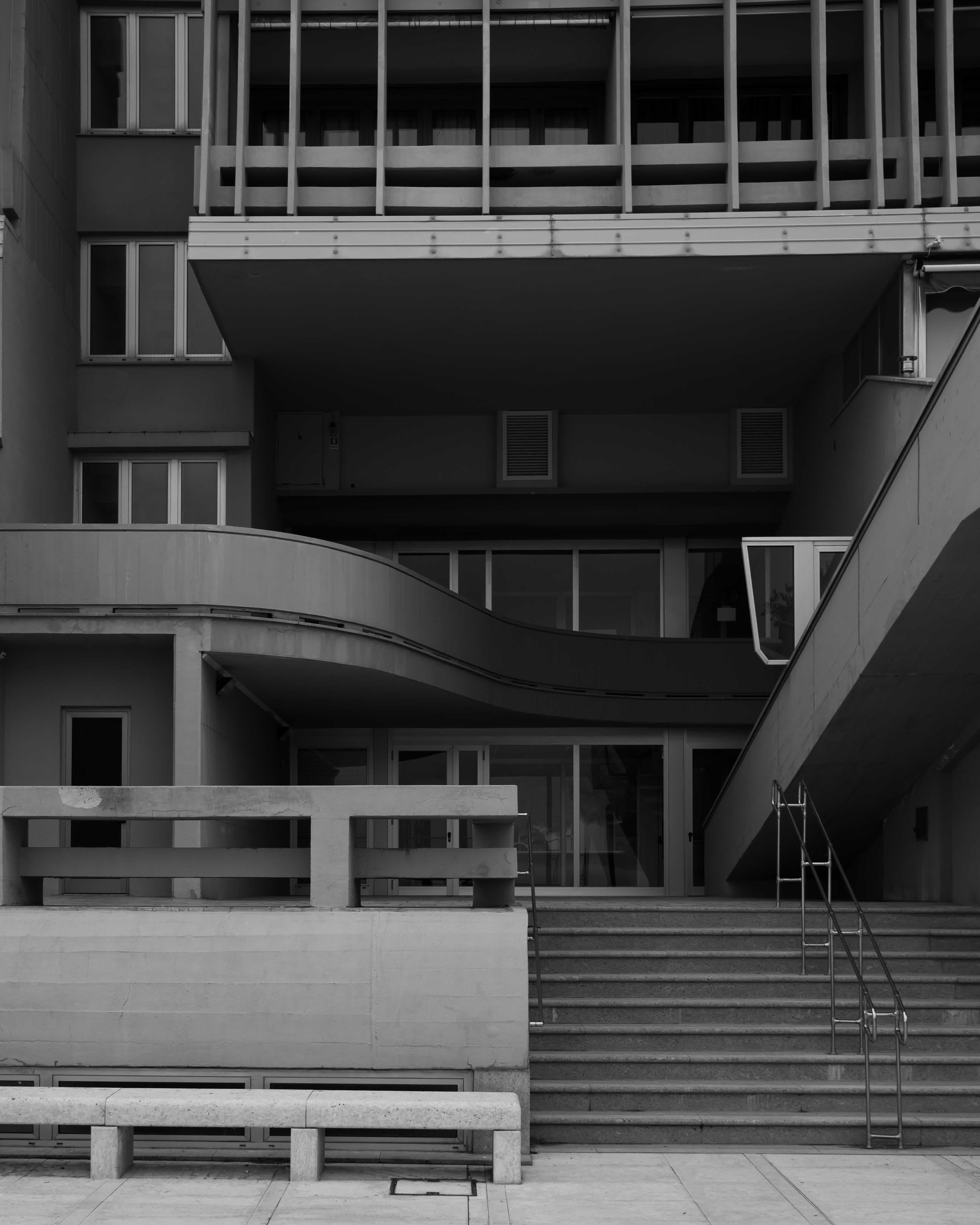 Hoteleingang mit verschlungener Architektur in schwarz-weiß, aus Normalperspektive